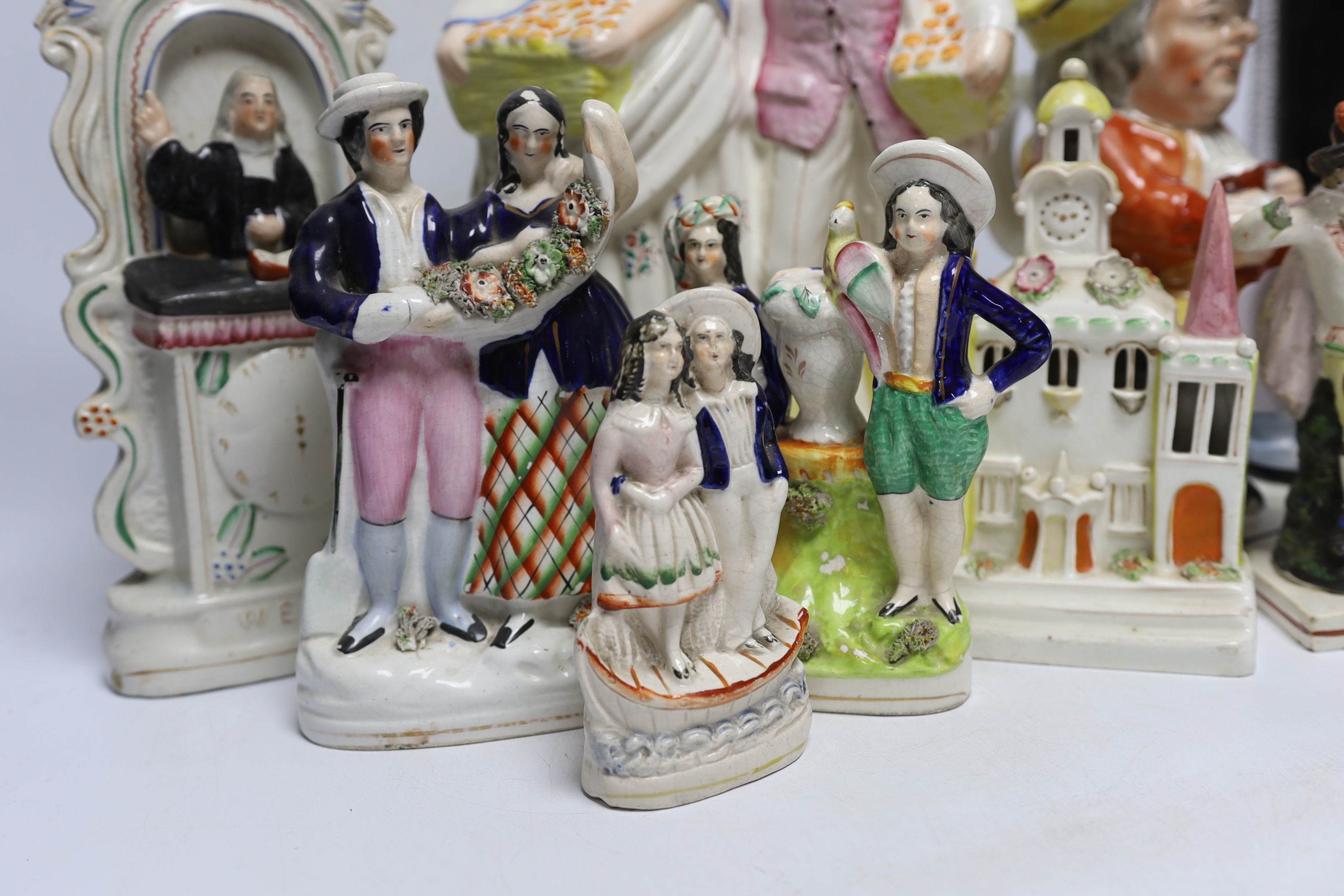 Seven 19th century Staffordshire figure groups including Orange Sellers and Wesley, together with a Toby jug, 35cm high